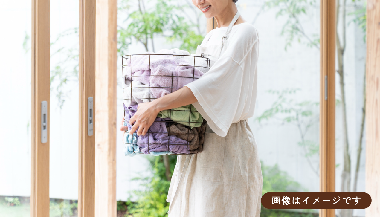 患者様の声 洗濯かごを持って家事中の女性の写真